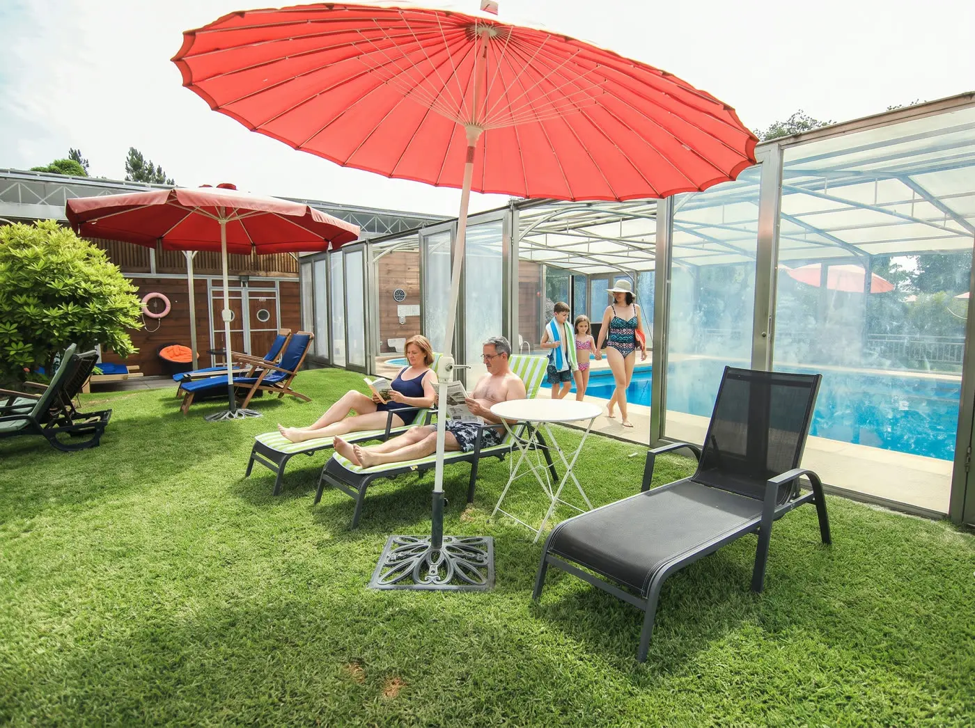 Famille se reposant sur les transats près de la piscine couverte