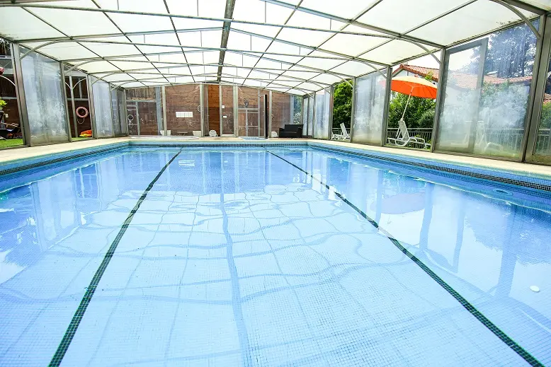 Piscine couverte à l'eau bleue avec transats